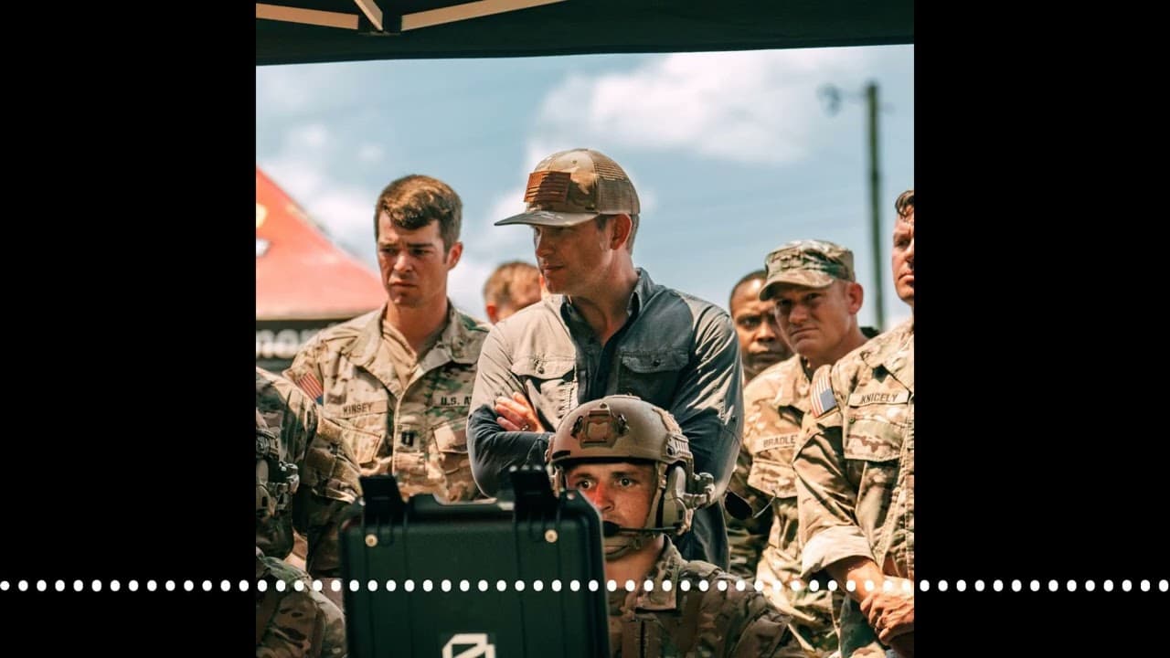 Military personnel observing a screen displaying data, with a drone or military technology in the foreground.